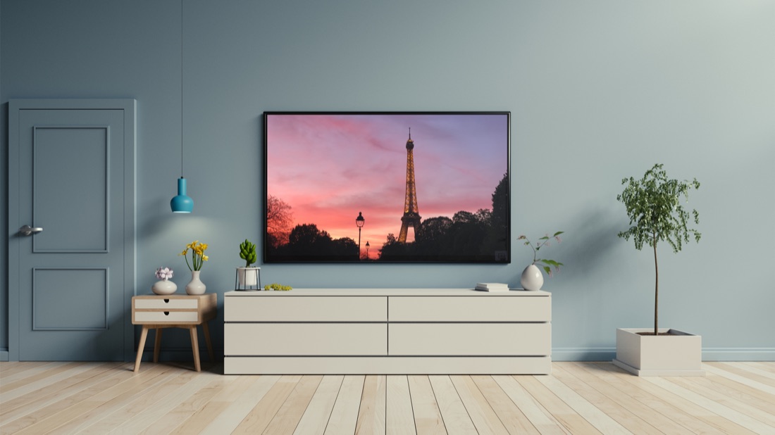A TV mounted on a living room wall, ready to receive a cast